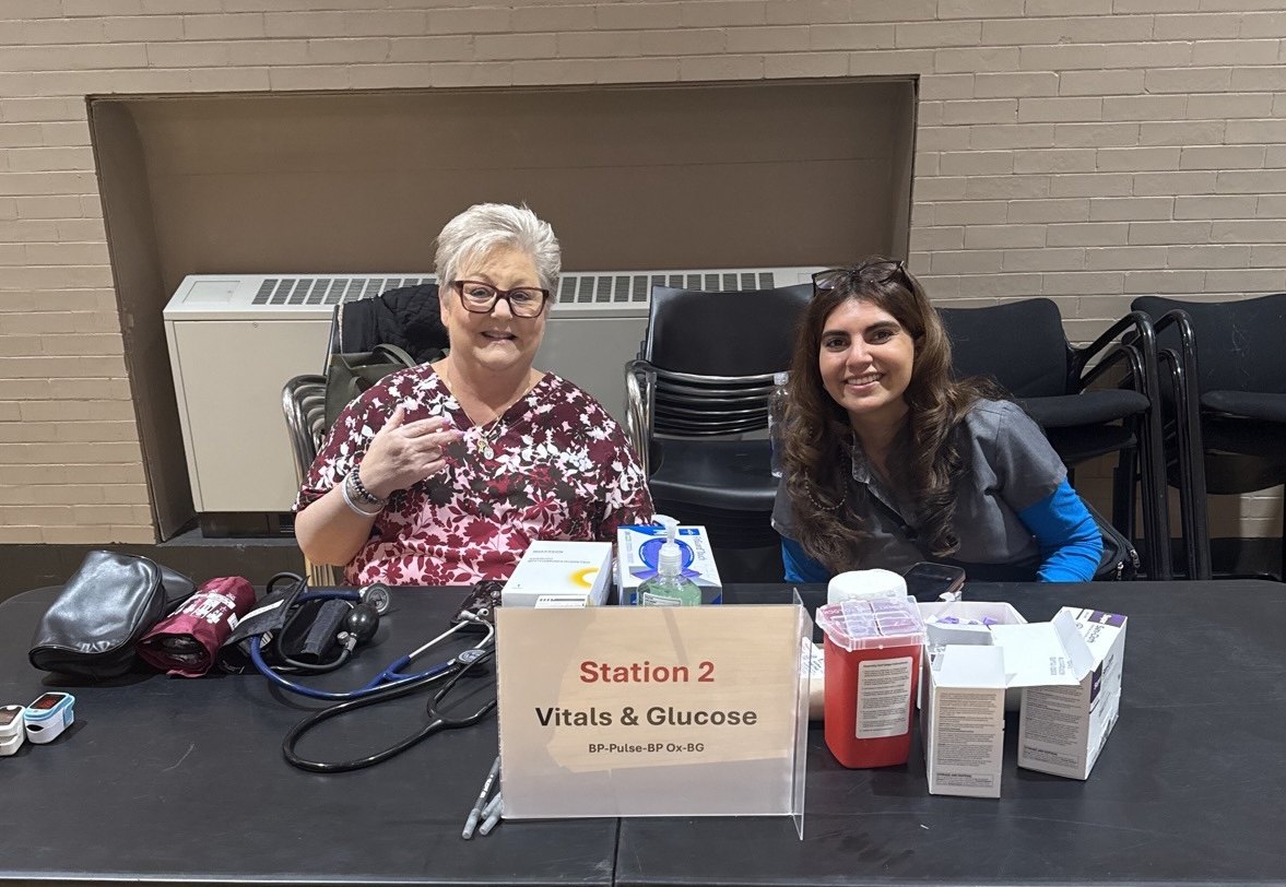 Volunteers at a vitals and glucose screening station