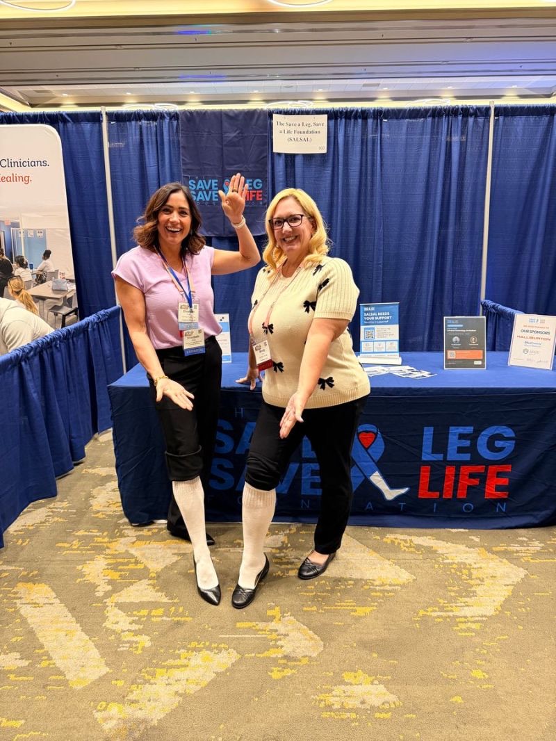 Two supporters wearing white socks at the SALSAL booth at the HEAL conference
